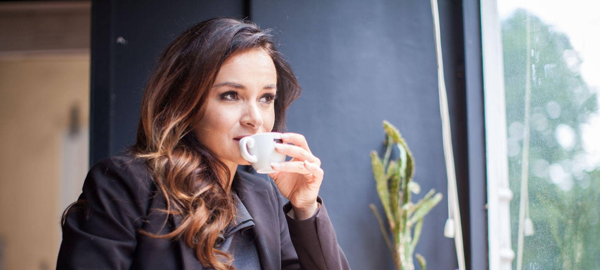 Eine Frau trinkt einen Espresso in einem Café